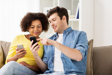 Image showing happy couple with smartphones at home