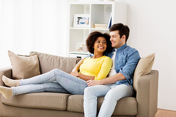 Image showing happy smiling international couple on sofa at home