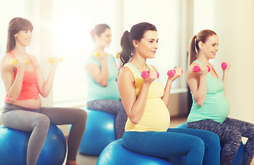 Image showing happy pregnant women exercising on fitball in gym