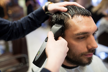 Image showing man and barber hands with trimmer cutting hair