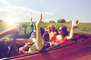 Image showing happy friends driving in cabriolet car at country