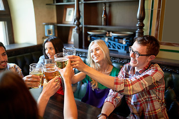 Image showing happy friends drinking beer at bar or pub