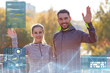 Image showing smiling couple waving hand outdoors