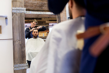 Image showing man and barber cutting hair at barbershop