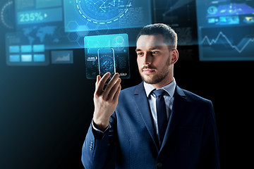 Image showing businessman with smartphone and virtual screens