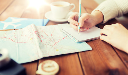 Image showing close up of traveler hands with notepad and pencil