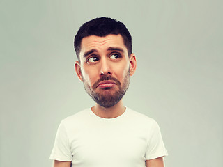 Image showing unhappy young man over gray background