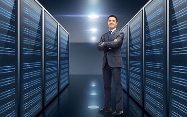 Image showing smiling businessman over server room background