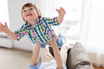 Image showing father hands holding happy little boy at home