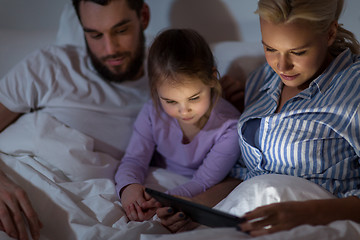 Image showing happy family with tablet pc in bed at home