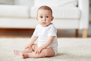 Image showing happy baby boy or girl sitting on floor at home