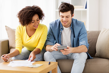 Image showing happy couple with papers and calculator at home