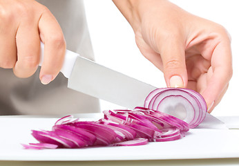 Image showing Cook is chopping onion