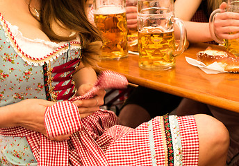 Image showing Beautiful young woman fixing her Dirndl at Munich Oktoberfest