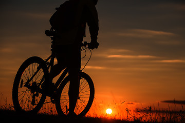 Image showing Silhouette of a bike on sky background during sunset