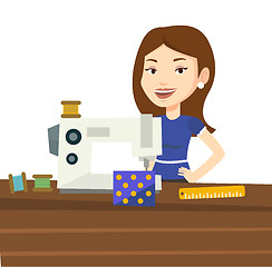 Image showing Seamstress using sewing machine at workshop.