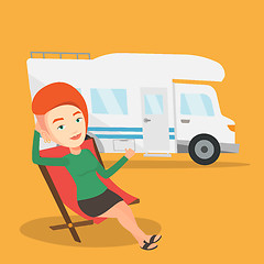 Image showing Woman sitting in chair in front of camper van.