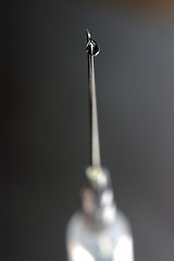 Image showing syringe close-up, focus on the drop