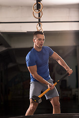 Image showing man workout with hammer and tractor tire