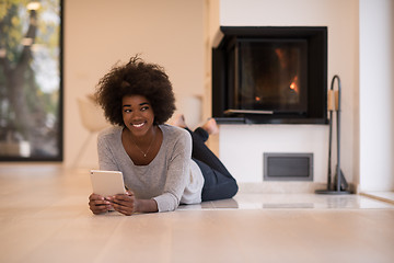 Image showing black women using tablet computer on the floor