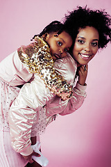 Image showing young pretty african-american mother with little cute daughter hugging, happy smiling on pink background, lifestyle modern people concept