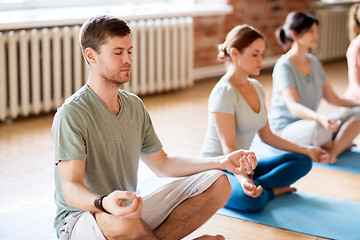 Image showing group of people making yoga exercises at studio