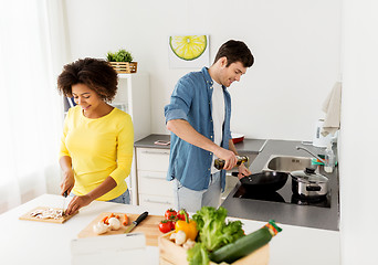 Image showing happy couple cooking food at home kitchen