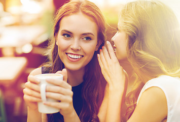 Image showing young women drinking coffee and talking at cafe