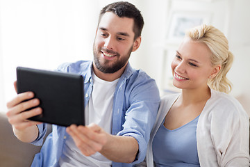 Image showing smiling happy couple with tablet pc at home