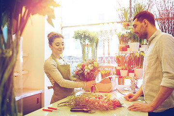 Image showing smiling florist woman and man at flower shop