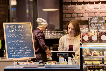 Image showing woman bartender at cafe or coffee shop cashbox