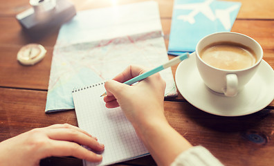 Image showing close up of traveler hands with notepad and pencil