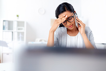 Image showing businesswoman calling on smartphone at office