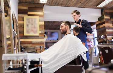 Image showing man and hairdresser with mirror at barbershop