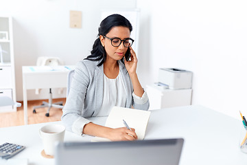 Image showing businesswoman calling on smartphone at office