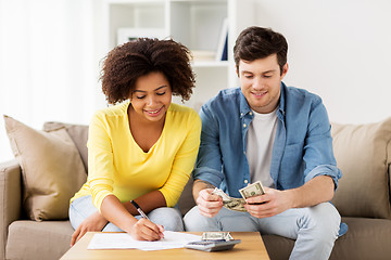 Image showing happy couple with papers and calculator at home