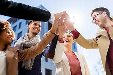 Image showing group of happy people making high five in city