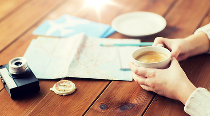 Image showing close up of hands with coffee cup and travel stuff