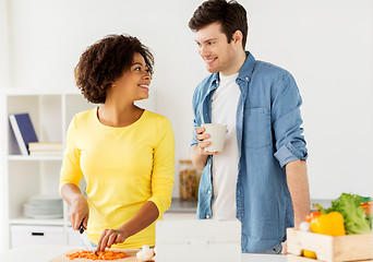 Image showing happy couple cooking food at home kitchen