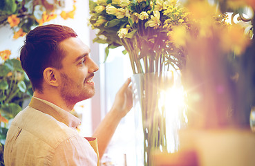 Image showing happy smiling florist man at flower shop