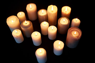 Image showing candles burning in darkness over black background