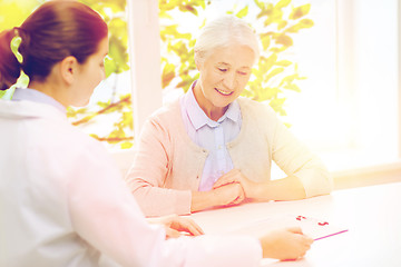 Image showing doctor with clipboard and senior woman at hospital