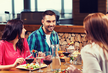 Image showing happy friends having dinner at restaurant