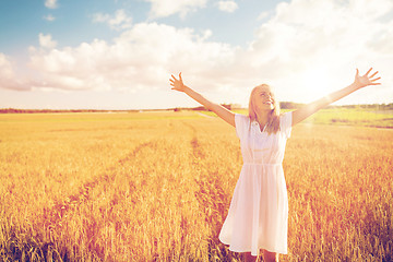 Image showing smiling young woman in white dress on cereal field