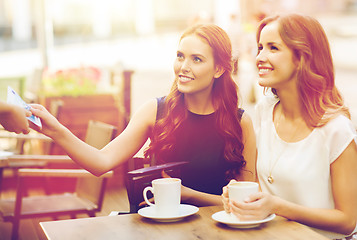 Image showing women paying money to waiter for coffee at cafe