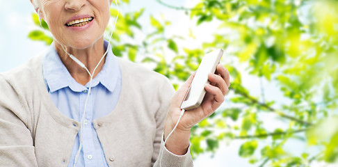 Image showing happy senior woman with smartphone and earphones