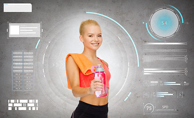 Image showing smiling sporty woman with water bottle and towel