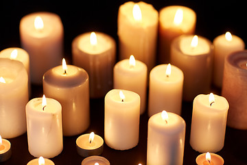 Image showing candles burning in darkness over black background