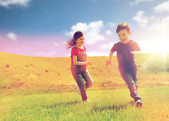 Image showing happy little boy and girl running outdoors