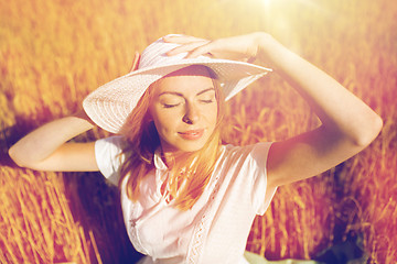 Image showing happy young woman in sun hat on cereal field